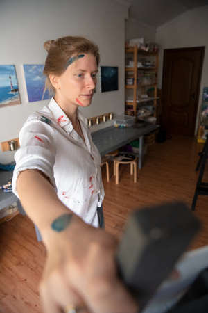 Portrait of a Woman Artist. Painting with oil paints. Creation. Copy Spaceの写真素材