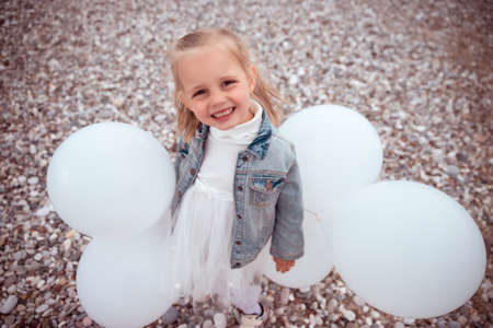 Happy Child Girl in White Dress with White Balloonsの写真素材