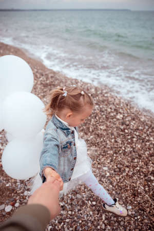 Cute Little Girl in a White Dress with White Balloonsの写真素材
