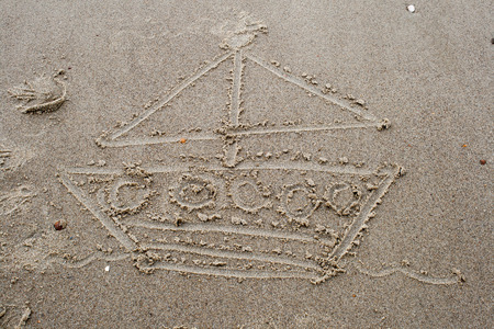 drawing a boat in the sand on beachの写真素材