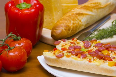 Baguettes with pepperoni on the plate and ingredientsの写真素材