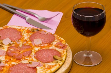 Pizza with salami & glass of wineの写真素材