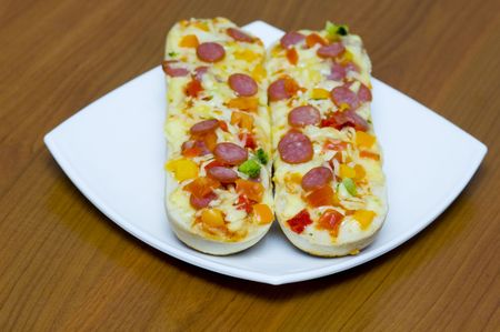 Baguettes with pepperoni on the plateの写真素材