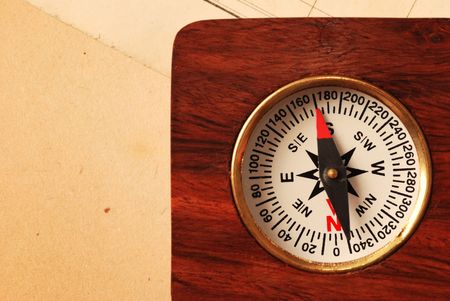 Antique wooden compass over old map background