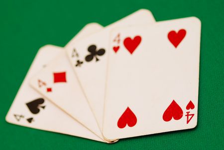 Four old playing cards on green background