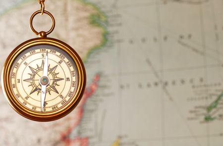 Antique brass compass over map background