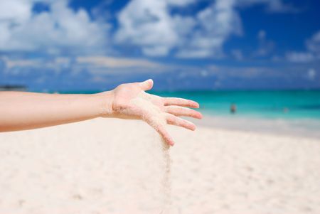 Coral white sand strewing from handの写真素材