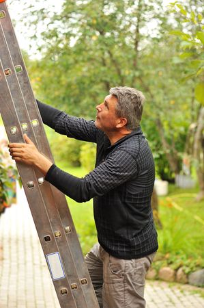 Man on the ladder at backyardの写真素材