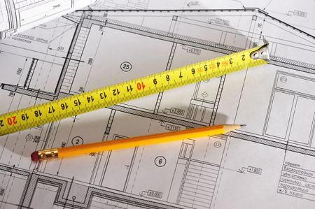 Pencil and tape meausure over house plan blueprintsの写真素材