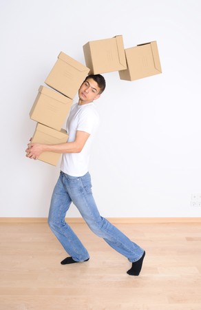 Young man carrying and dropping his stack of moving boxesの写真素材
