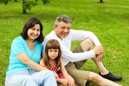 Mature couple with daughter on grass outdoors