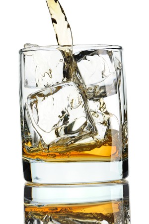 Pouring whiskey in glass with ice isolated on whiteの写真素材