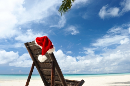 Santa's hat and chaise lounge on the beachの写真素材