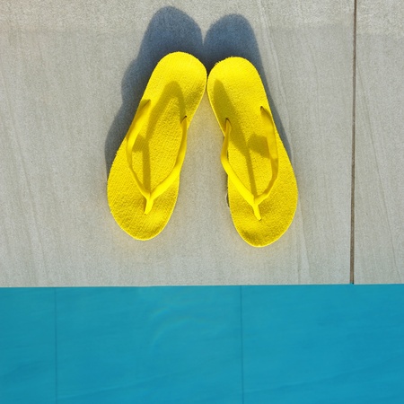 Yellow sandals by a swimming pool の写真素材