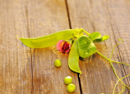 Fresh green peas pods on a wooden tableの写真素材