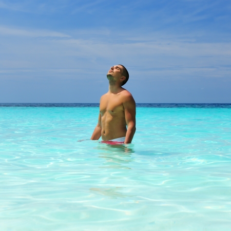 Man in water at tropical beachの写真素材