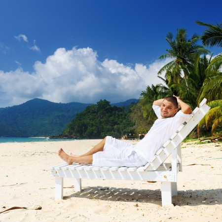 Man in white relaxing on a tropical beachの写真素材