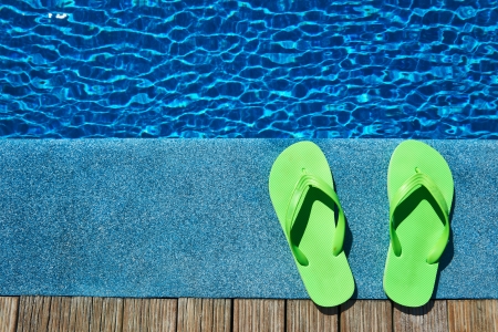 Green slippers by a swimming pool Green slippers by a swimming pool