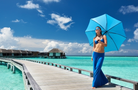Woman on a tropical beach jetty at Maldivesの写真素材