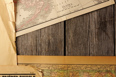 Old torn paper and maps on wood planks background