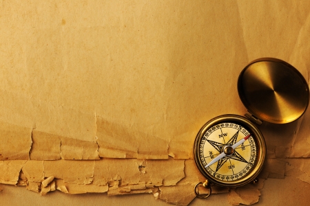 Antique brass compass over old paper backgroundの写真素材