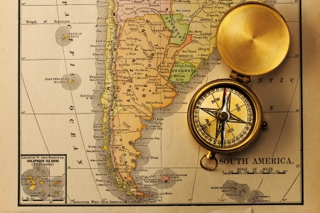 Antique brass compass over old XIX century map