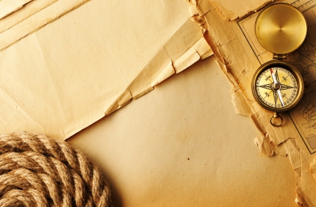 Antique brass compass and rope over old map