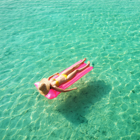 Woman relaxing on inflatable mattress at the beachの写真素材