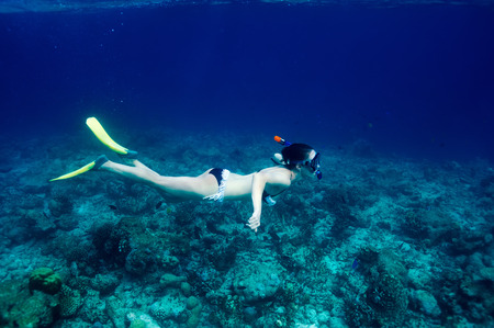 Woman with mask snorkeling in clear water の写真素材
