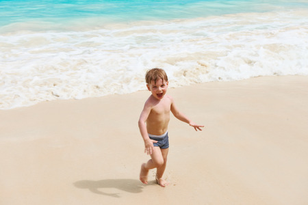 Two year old baby boy playing on beach at Seychellesの写真素材