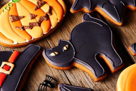 Halloween homemade gingerbread cookies over wooden tableの写真素材
