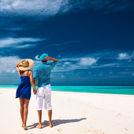 Couple in blue on a tropical beach at Maldivesの写真素材