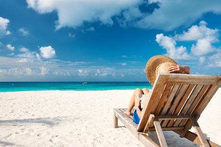 Young woman reading a book at the beach