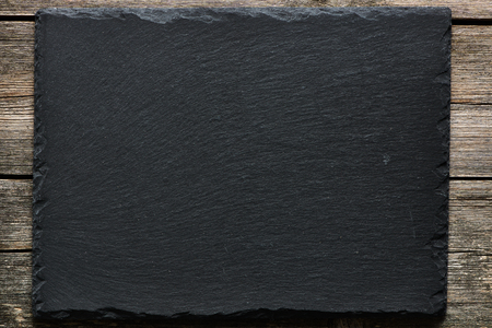 Slate over old wooden backgroundの写真素材