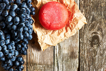 Fresh grapes and cheese on old wooden backgroundの写真素材