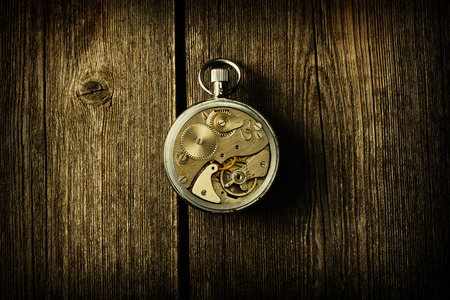 Clockwork mechanism over wooden backgroundの写真素材