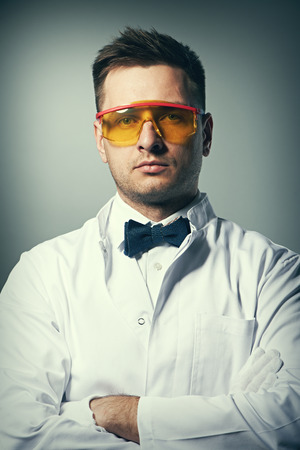 Scientist in yellow glasses against grey backgroundの写真素材