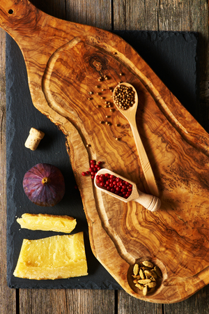 Olive wood cutting board with spices and fig over slateの写真素材