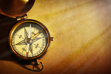 Antique brass compass over old paper backgroundの写真素材