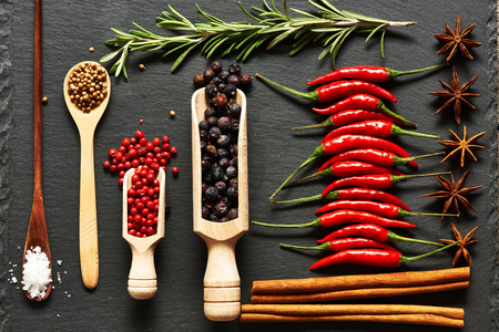 Red hot chili peppers and spices on slate background