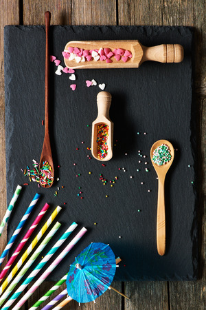 Drinking straws and sugar sprinkle dots on slate backgroundの写真素材