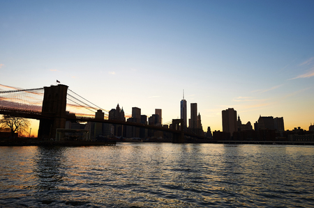 Brooklyn Bridge with lower Manhattan skyline in New York City at eveningの写真素材