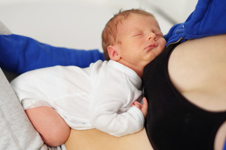 One week old newborn baby with his motherの写真素材