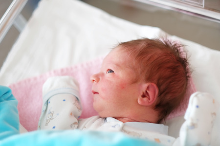 One day old newborn baby in bedの写真素材