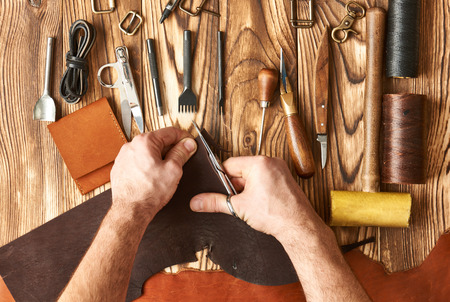 Man working with leather using crafting DIY tools