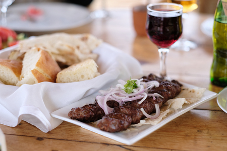 Traditional delicious kebab with onion and glass of wineの写真素材