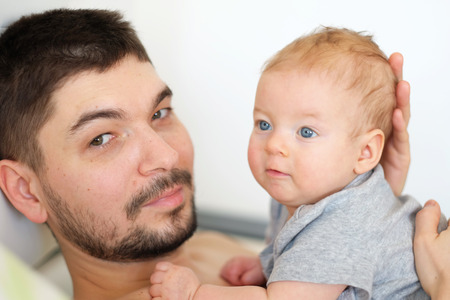 Newborn baby with his father. Shallow depth of field.の写真素材