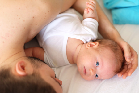 Newborn baby with his father. Shallow depth of field.の写真素材