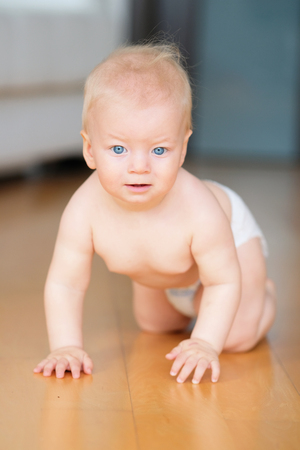 Baby boy crawling on floorの写真素材
