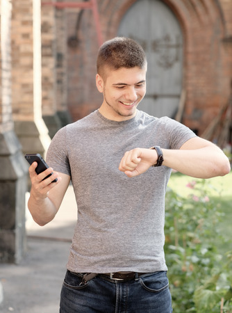 Outdoor portrait of young man in urban context with mobile phoneの写真素材